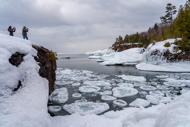 People take photos of the scene where pancake ice is formed on Lake Superior at Presque Isle Park in Marquette on Tuesday, March 3, 2020 in Michigan's Upper Peninsula.