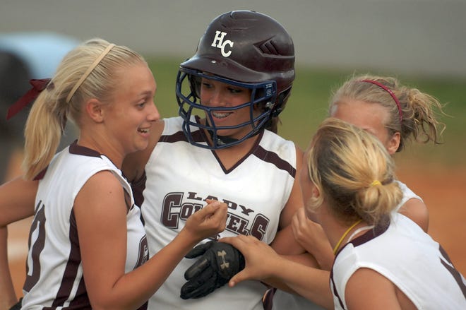 Henderson County's Katelyn McMillan, center, is congratulated by teammates after she hit her second straight home run during the 2009 Second Region Tournament semifinal against Hopkins County Central in Eddyville.