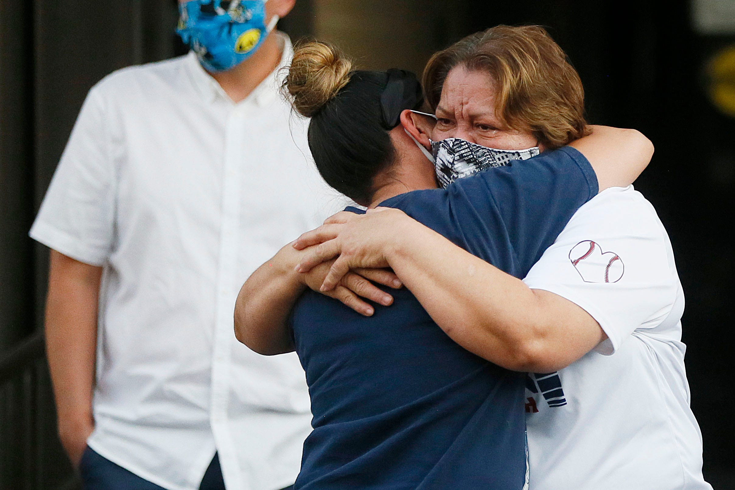 El Pasoans hug at a drive-through prayer vigil for Guillermo "Memo" Garcia on Monday, April 27, at Del Sol Medical Center in El Paso. Garcia died on Saturday after being hospitalized at Del Sol Medical Center for nearly nine months. He was shot on Aug. 3 in what federal prosecutors have described as a domestic terror attack.