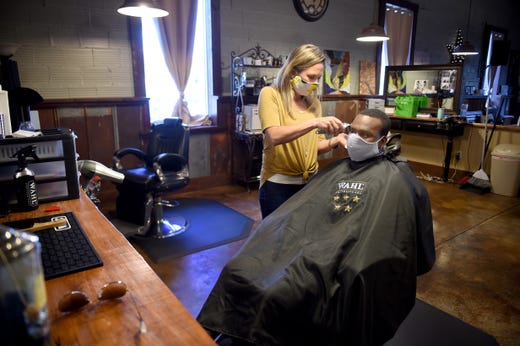 Shelley Craft, owner of The Men's Refinery BarberSpa  gives a haircut to Kenneth Gregory at her salon in Augusta, Ga., Friday morning April 23, 2020. 