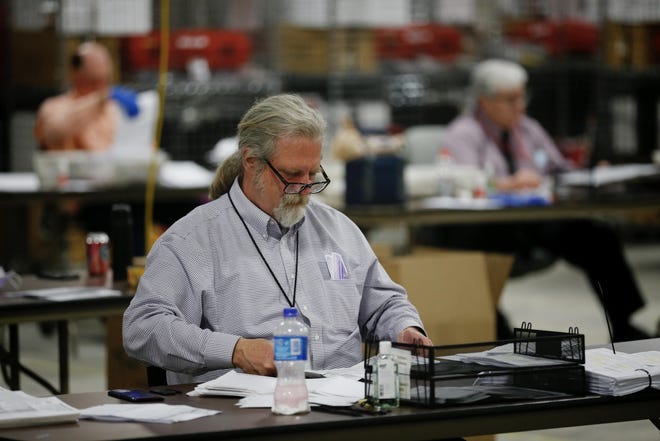 Election workers open and verify ballots as they send them along in the counting process at the Hamilton County Board of Elections on April 28, 2020.