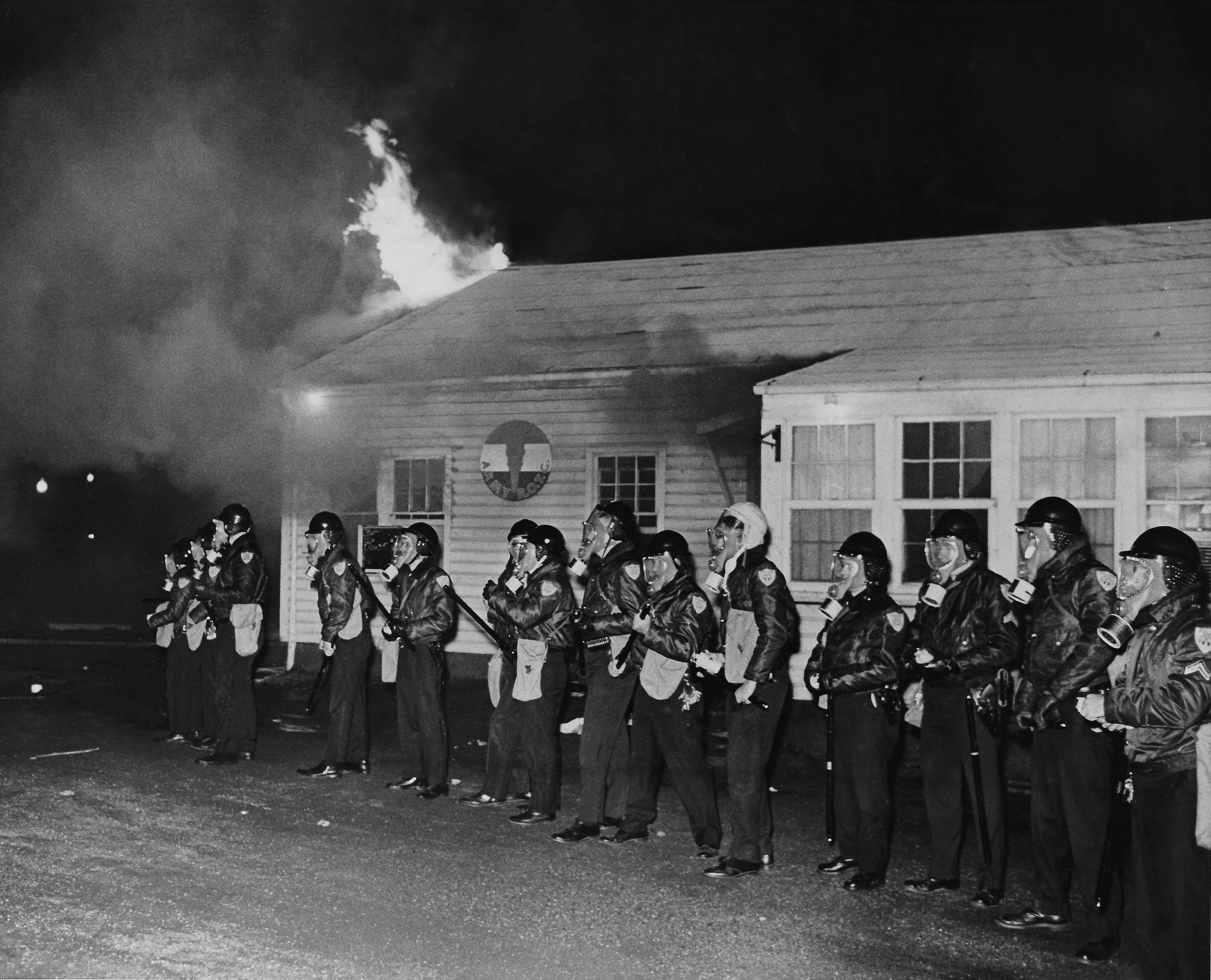 With riot batons at the ready, police wearing gas masks stand in front of the burning ROTC building at Kent State during a night of unrest on May 2, 1970.