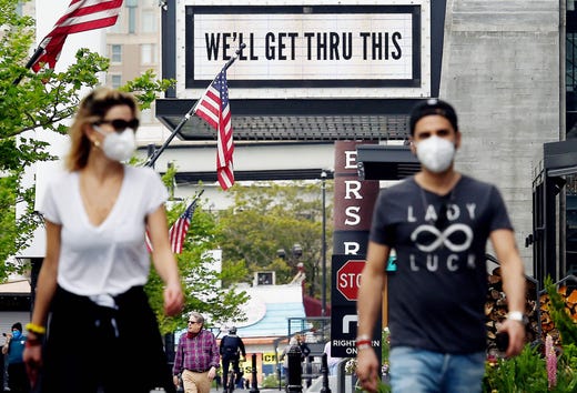 Pedestrians walk past a sign in front of the The Anthem, a popular live music venue, displaying a message of support amid the coronavirus pandemic, on April 29, 2020, in Washington, DC.