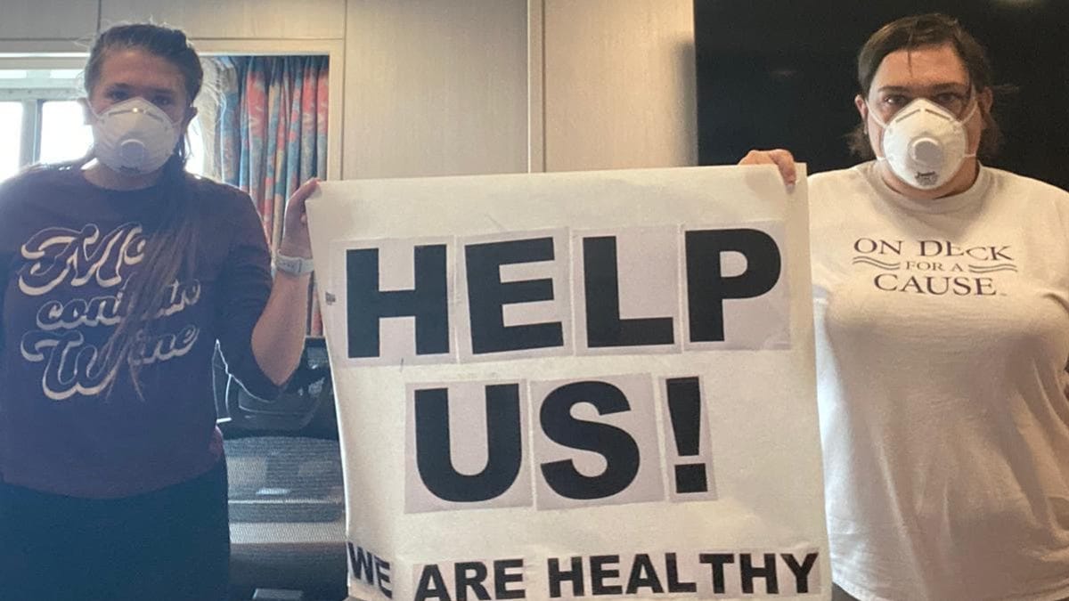 American crew member Melinda Mann (right) is seen protesting her detainment on the MS Oosterdam with a colleague.