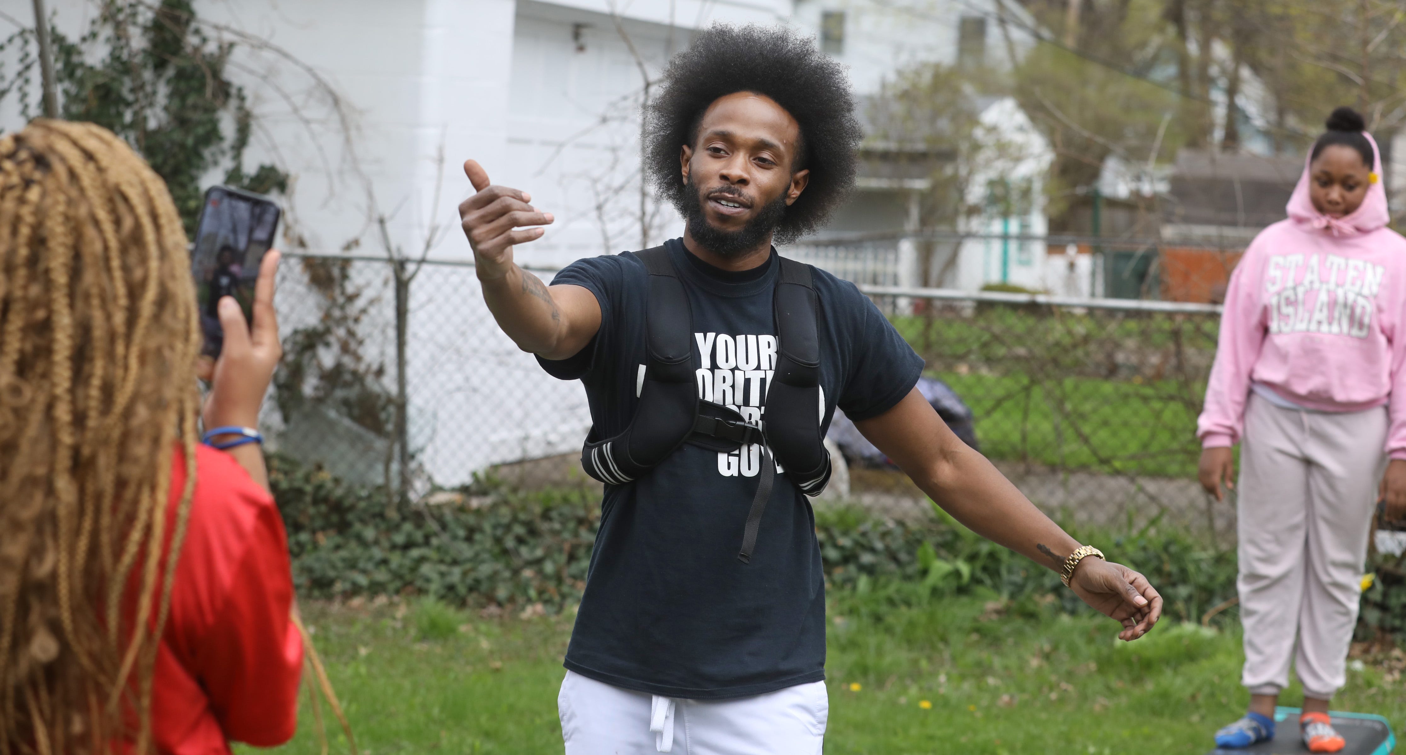 With his niece Ja'zinah Powell, 18, running the Facebook Live feed using his phone, Toshman Powell invites his followers to "come on and have some fun," as he hosts his "Quarantine Fitness Party" for his Facebook Live followers from the back yard of his home in Rochester Wednesday, April 29, 2020.