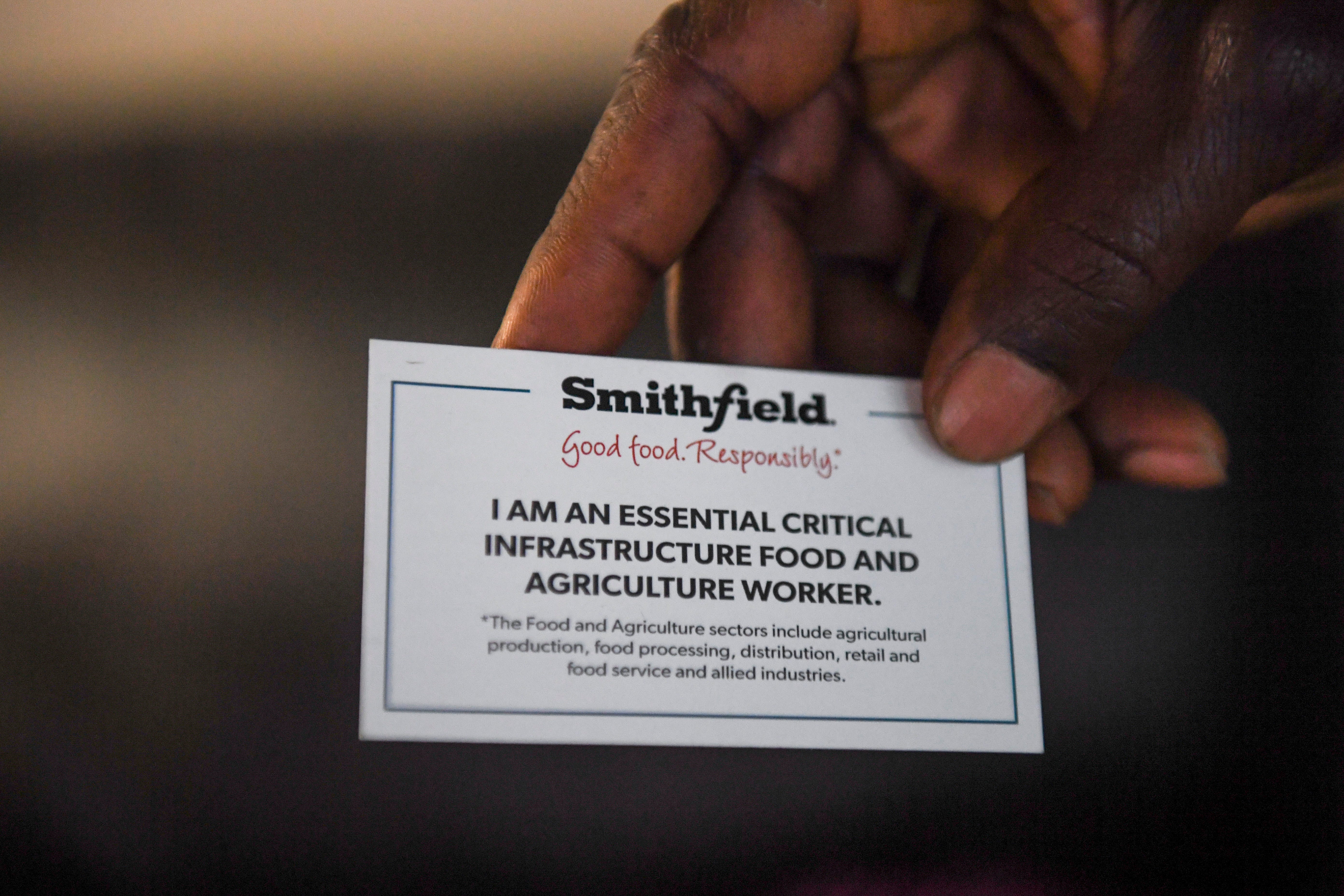 John Deranamie holds an essential worker card given to him from Smithfield.