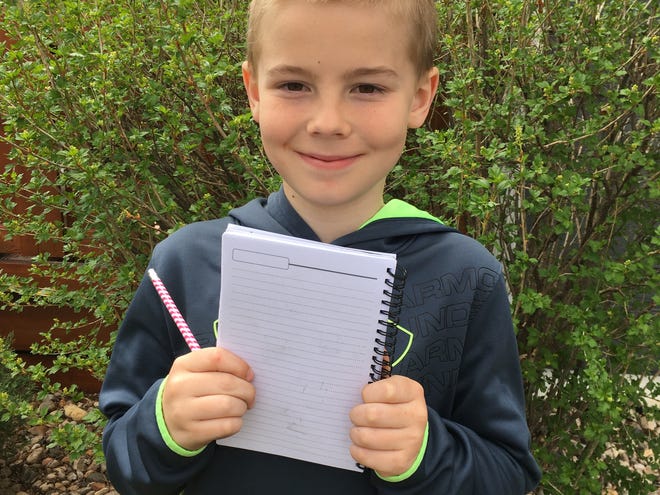 William Korman, 9, holds a notebook for his comic ideas.