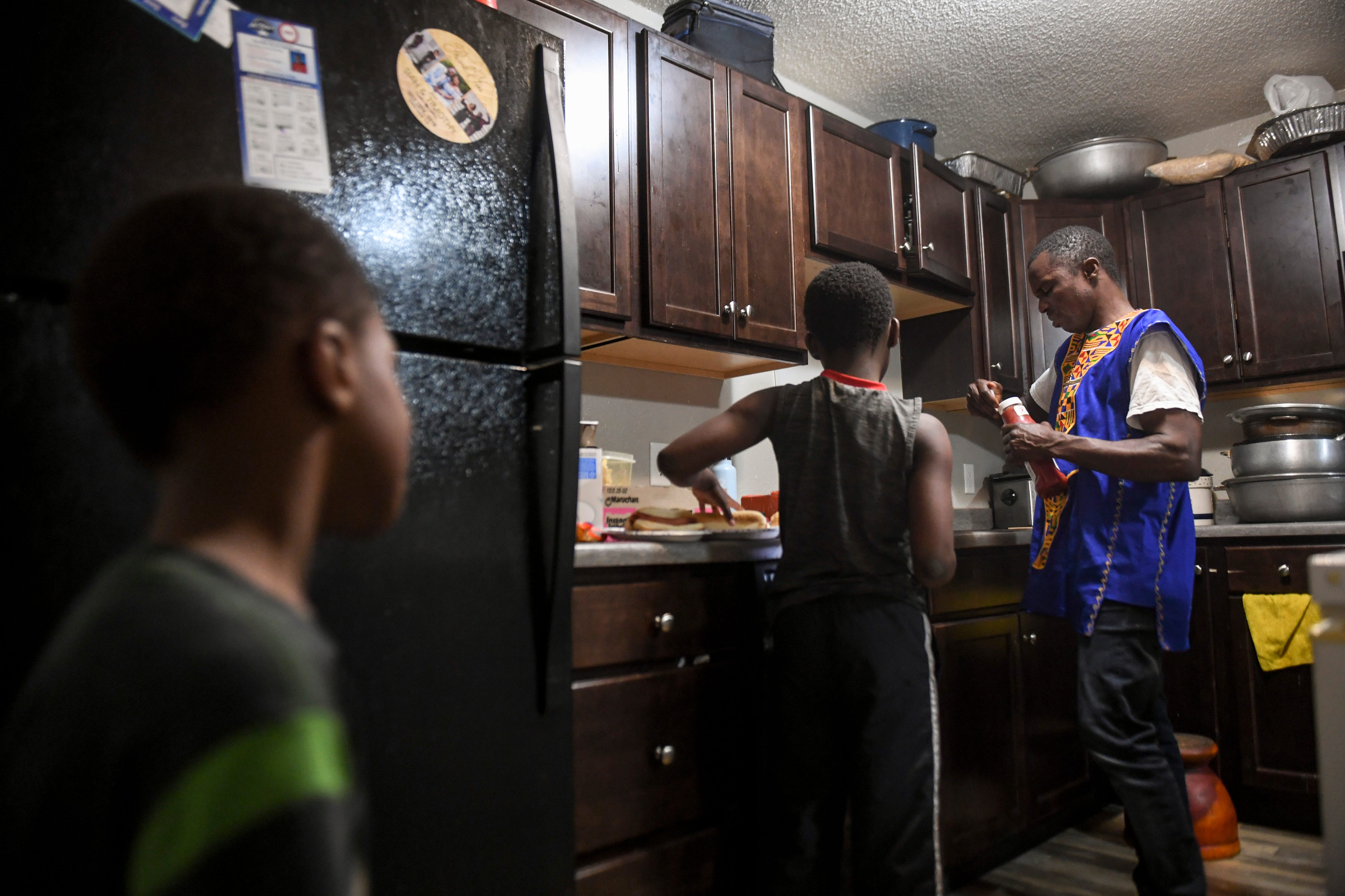 John Deranamie cooks dinner for his sons, Shadrach Cole, 4, and Joel Cole, 9, on Wednesday, April 29, 2020 at his home in Sioux Falls, S.D. 