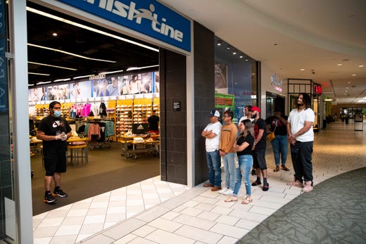 People wait in line at a store in the La Palmera Mall on Friday, May 1, 2020 the first day it has been open since the COVID-19 outbreak. 