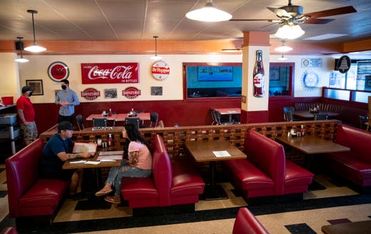 `Two people sit at a table at Town and Country Cafe on Friday, May 1, 2020, the first day of sit-down dinning since the COVID-19 outbreak.