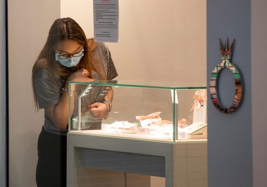 An employee Pandora inside La Palmera Mall wears a mask on Friday, May 1, 2020 the first day the mall has been open since the COVID-19 outbreak. 
