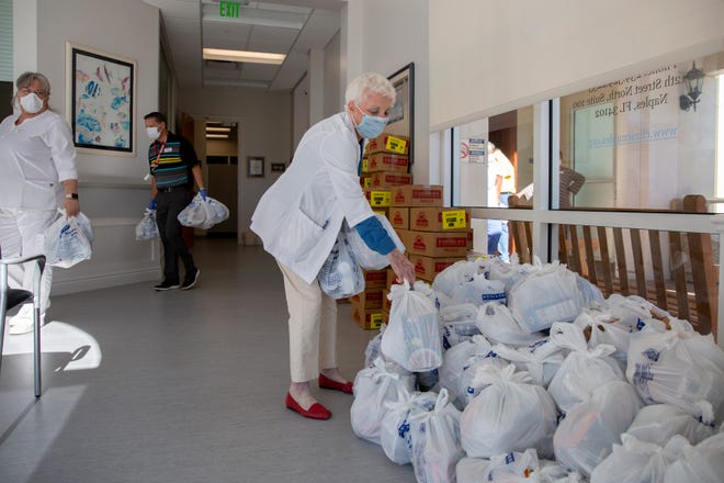 Neighborhood Health Clinic co-founder Nancy Lascheid, stack bags of donated goods from St. Matthew's House, Friday, May 1, 2020, in Naples.