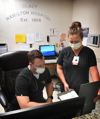 Olney Hamilton Hospital ER director Colter Garrett, RN and Samantha Isbell, MSN, look over a patient's case. Olney, Texas has seen four positive cases and one death from COVID-19 at this time.