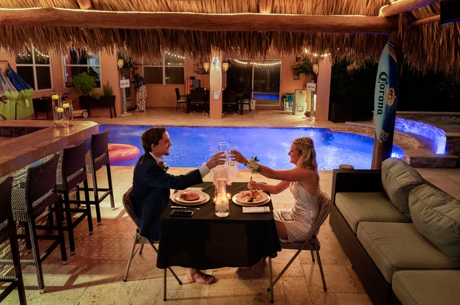 April 18, 2020: Royal Palm Beach, FL, USA Mandatory   Royal Palm Beach High School seniors Dominick Grosso and Paige Houck toast each other as they spend their prom night together in the backyard of the Grosso home. Their school prom was canceled because of the coronavirus.