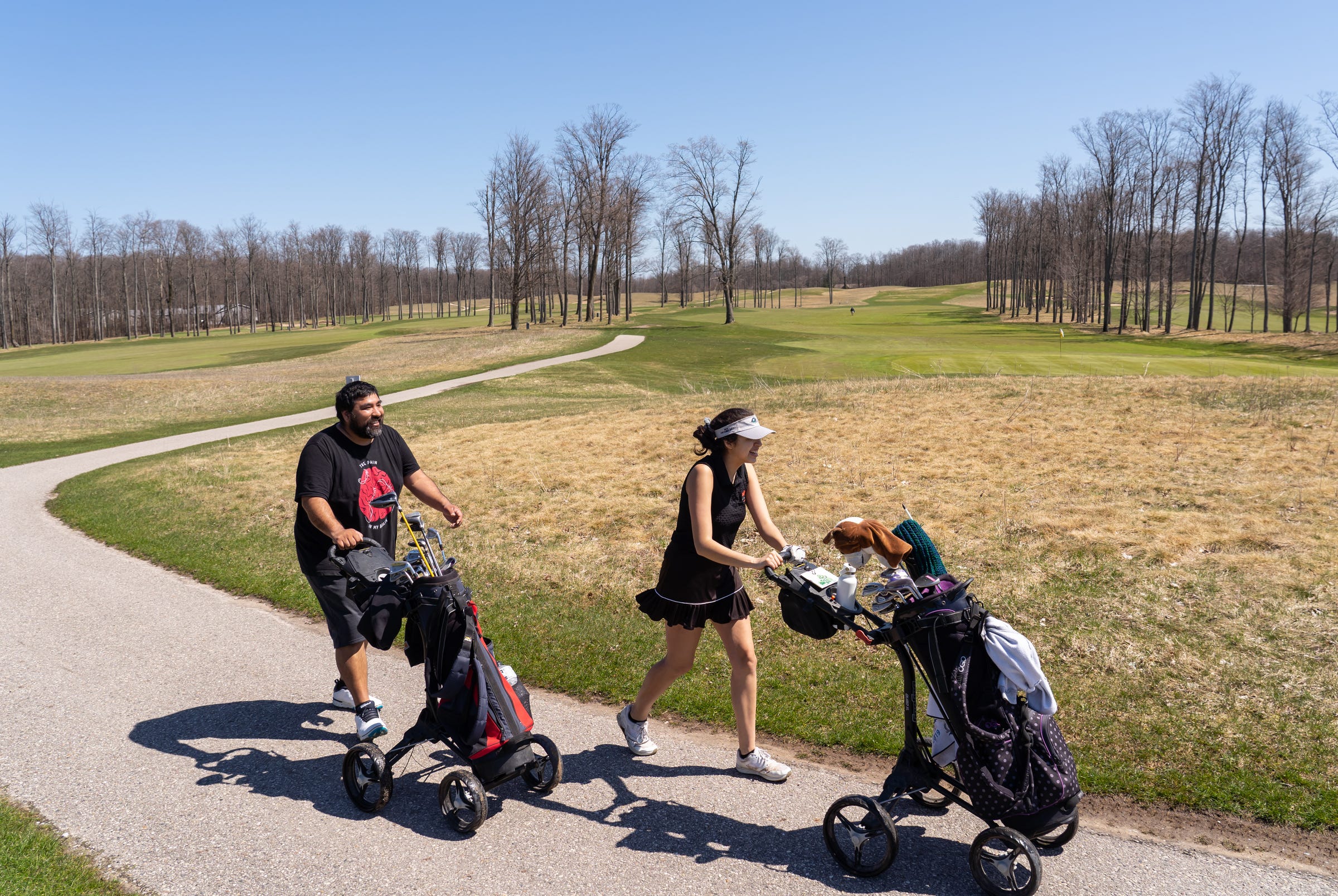 Juanita De La Cruz of Saginaw and her father Juan De La Cruz make their way to the next tee while playing a round of golf on the opening day for walking golfers on the Tradition course at Treetops Resort in Gaylord on Friday, May 1, 2020. The two took advantage of the warm weather while in town with Juan's wife as she is in the area helping do health care during the COVID-19 pandemic. Juanita, who plays golf for Saginaw Heritage, was playing for her first time since November.