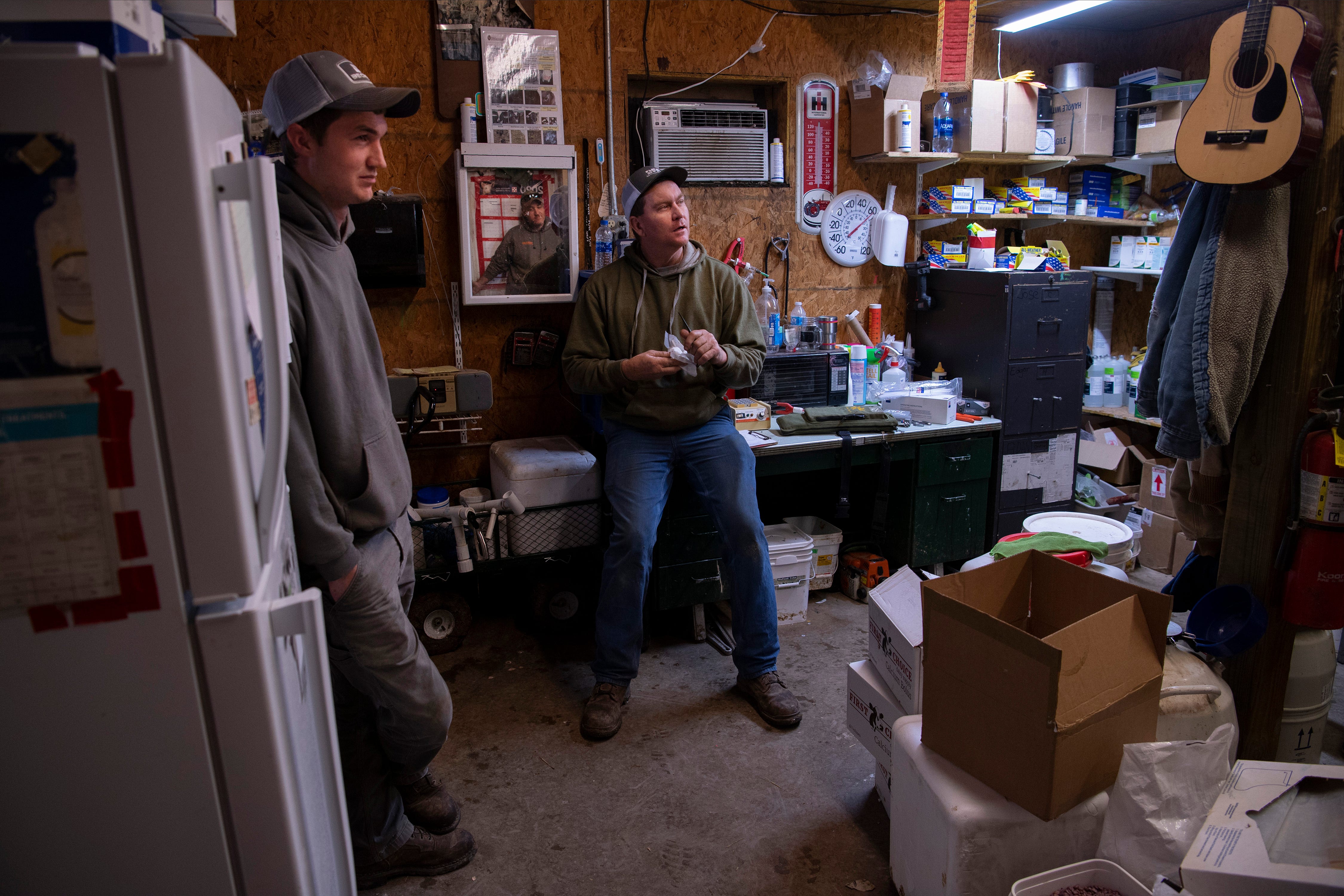 Brian Rexing of Owensville, Ind., center, meets with his employees, Travis Jacob, left, and Dan Mercer, reflected in mirror, to discuss future plans for New Generation Dairy.