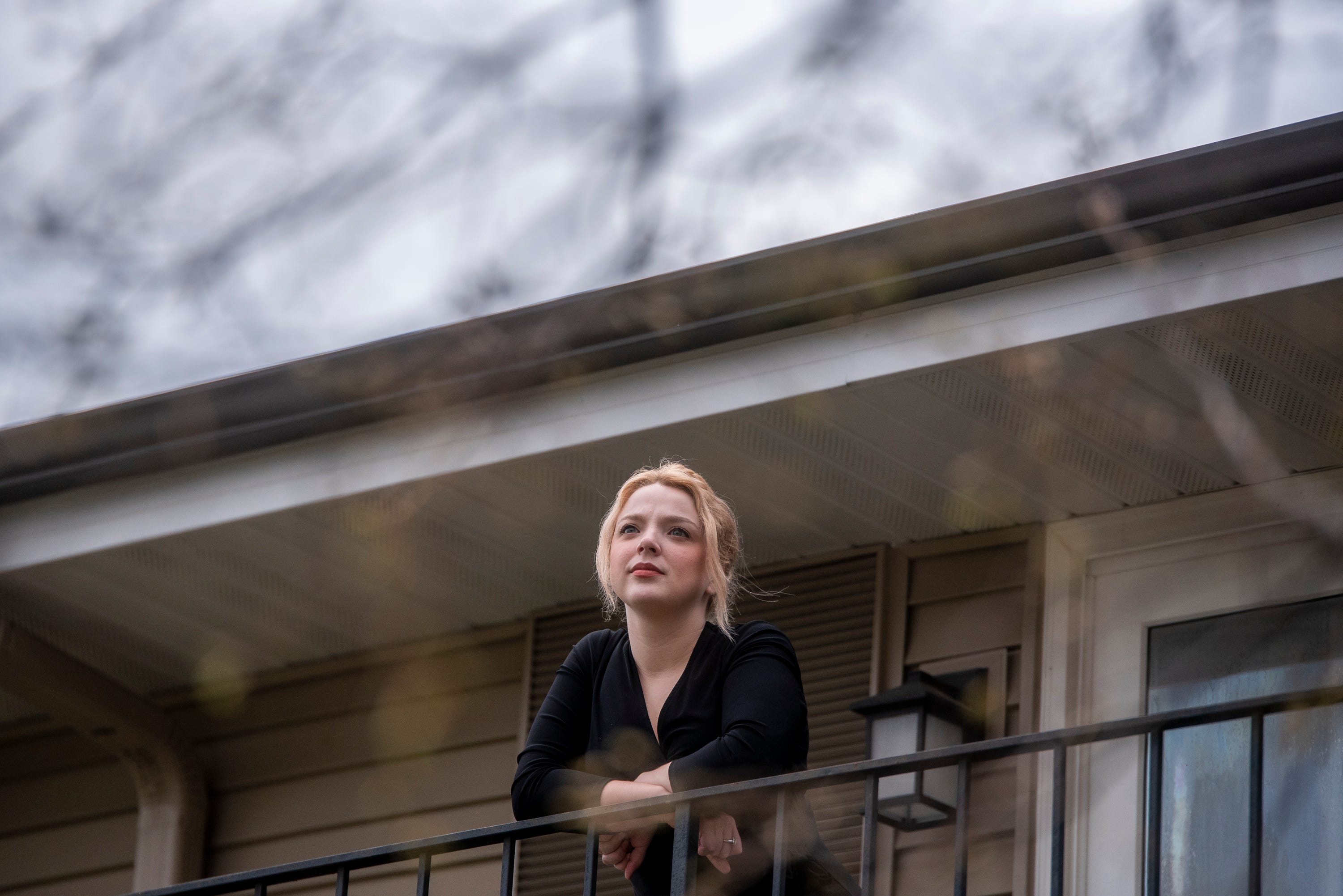Rachel Metcalfe, 22, poses on her balcony in Naperville, Illinois, on Friday, May 1, 2020. Metcalfe went from having a full-time job and living comfortably to applying for unemployment and wondering how she was going to pay rent as she recovered from COVID-19.