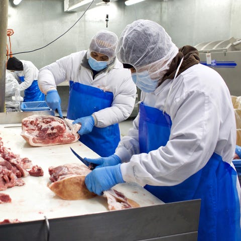 Butchers at Nicky USA cut up a pig carcass on Apri
