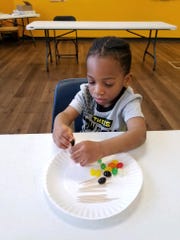Amir Morris works on a craft at the Carl H. Lindner YMCA children's program.
