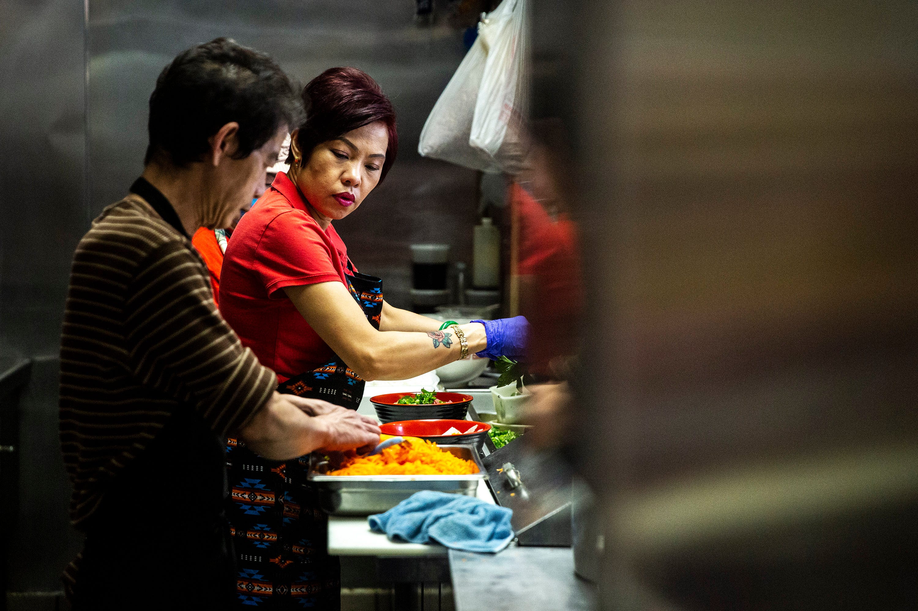 Brenda Tran, owner of the Vietnam Cafe, works in the kitchen with her staff to prep and prepare to-go orders May 3 in the Merle Hay Mall food court in Des Moines, Iowa.