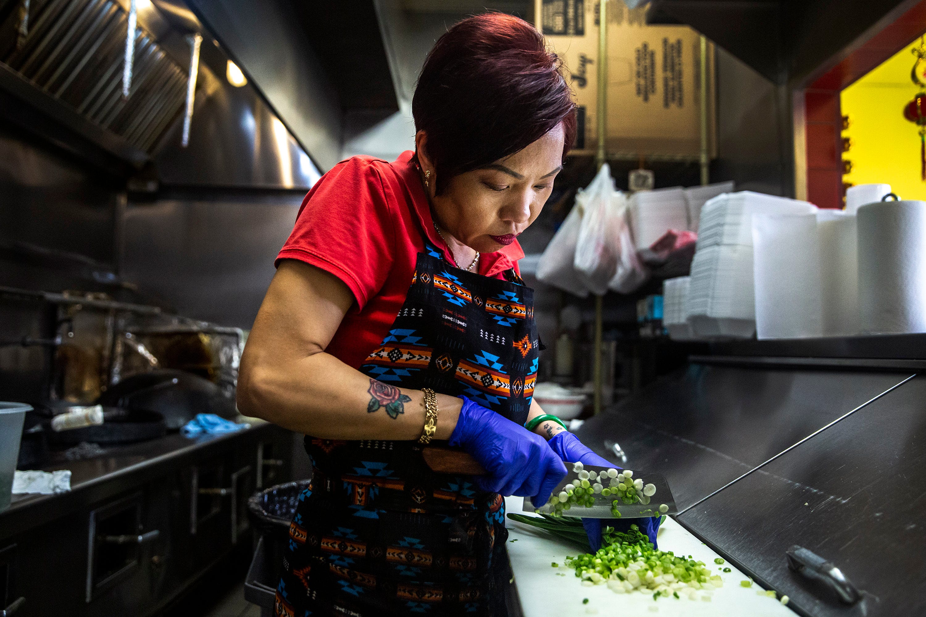 Brenda Tran chops scallions in the Vietnam Cafe kitchen on Sunday, May 3, 2020, at the Merle Hay Mall food court in Des Moines, Iowa. 