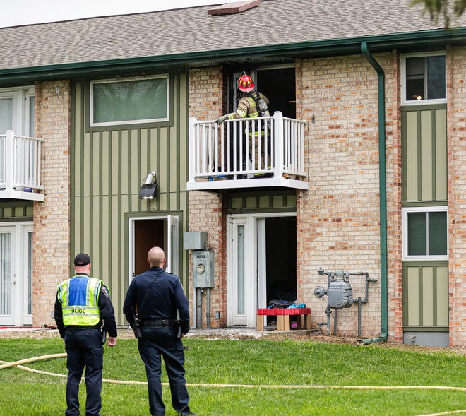 Two City of Fond du Lac Police officers watch Tuesday, May 5, 2020 as a Fond du Lac Fire/Rescue member looks over a burnt area where an apartment unit was on fire at 691 east Scott Street in Fond du Lac, Wis. Doug Raflik/USA TODAY NETWORK-Wisconsin
