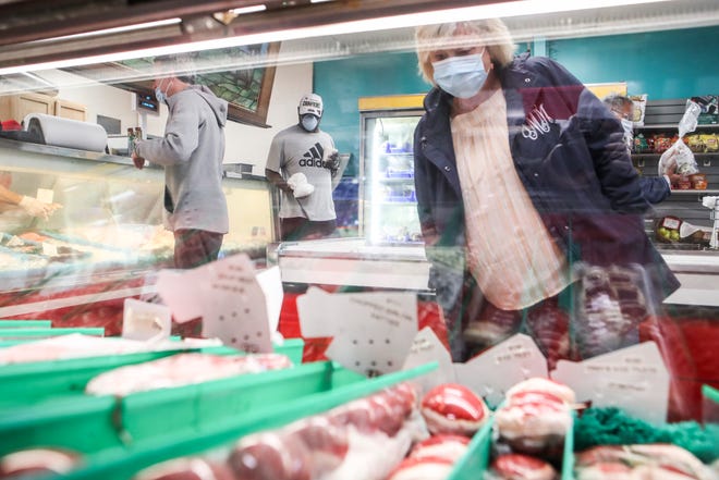 A consumer is seen shopping the meat case at Kingsley Meats and Catering on Taylorsville Road in May 2020.