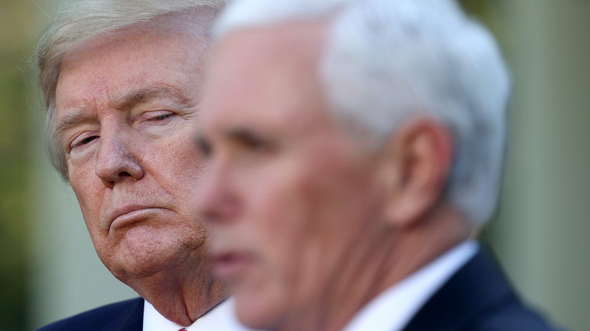 Donald Trump listens as Vice president Mike Pence answers questions during the daily briefing of the coronavirus task force in the Rose Garden of the White House on April 27, 2020 in Washington, DC. 