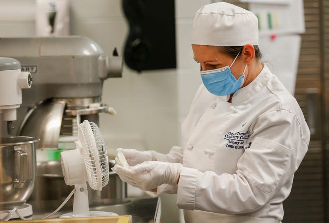 Ondi Burns, a culinary student at OTC, cools off a piece of sugar that she will mold into a goldfish for one of her final projects before graduating. She was glad to be able to return to in-person classes at OTC to finish her degree.