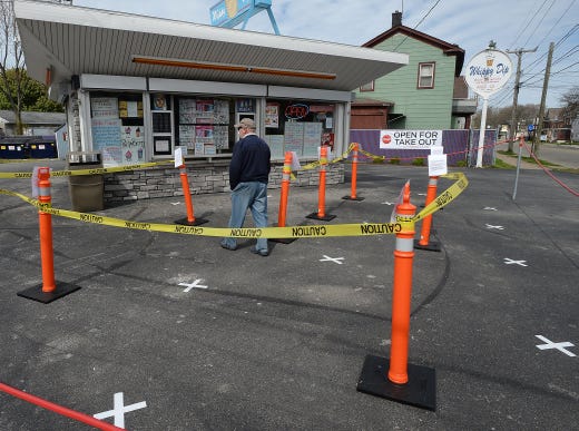 No need for social distancing on this day at the Whippy Dip ice cream stand in Erie, Pa. on May 5, 2020. Ed Beck, center, walks across the white X's placed six feet apart to help customers practice social distancing due to the COVID-19 coronavirus pandemic.