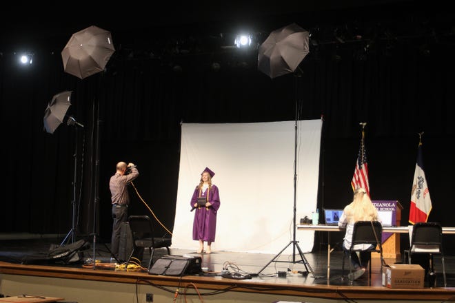 Photographer Tim McConnell takes formal pictures of Indianola seniors in the high school auditorium. Indianola High School seniors posed for a formal graduation photo one by one on May 7 to maintain social distancing. A formal ceremony has been scheduled for June 28.