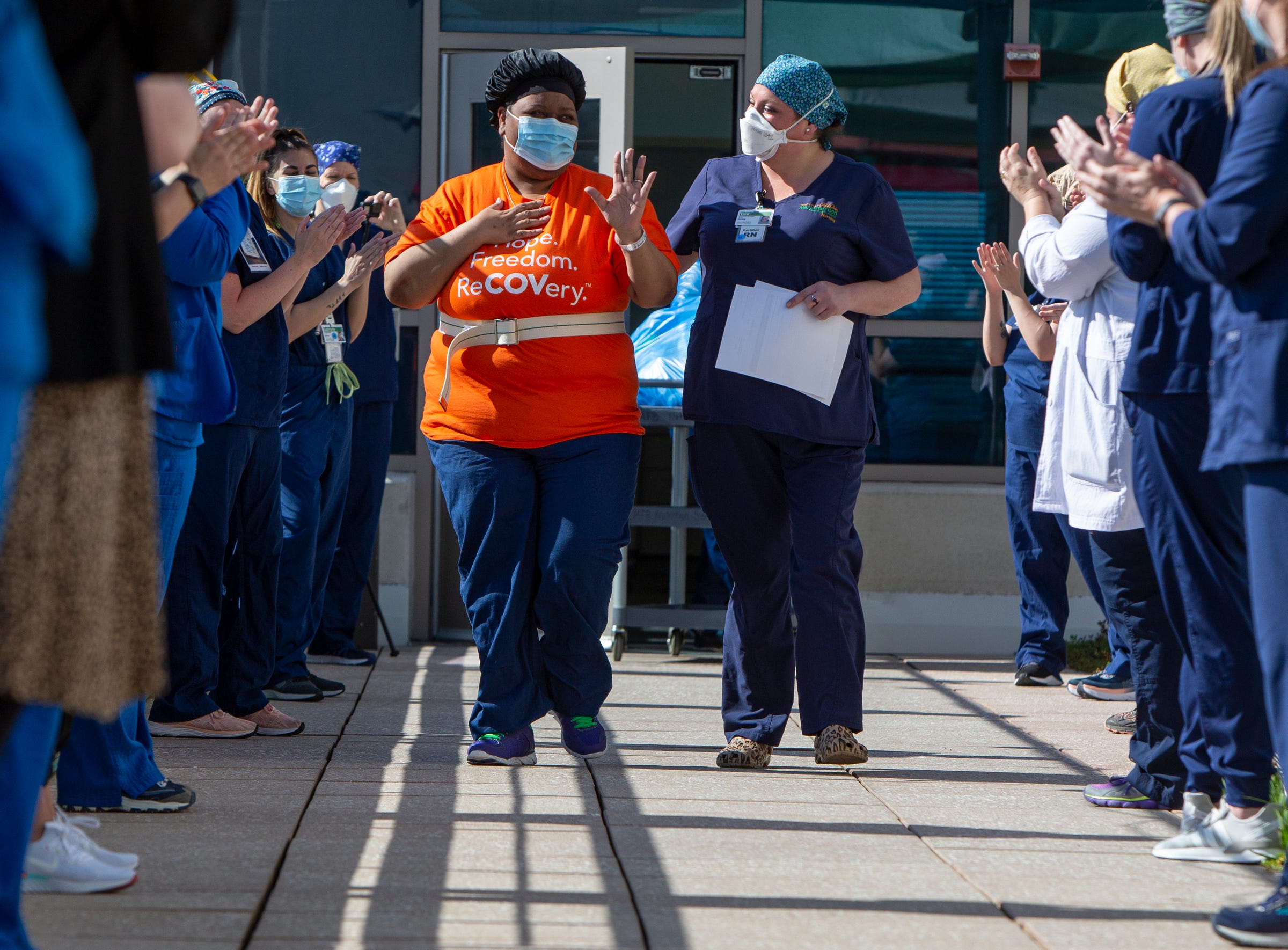 Charlunda Thompson, 45, of Inkster gets a "clap out" from the medical team at the Mary Free Bed Rehabilitation Hospital in Grand Rapids as she is finally able to depart from a COVID-19 recovery unit. Thompson, a hospice nurse at Henry Ford Hospital, was diagnosed with COVID-19 in March and was placed on a ventilator for 16 days. She's been recovering in the Grand Rapid hospital's COVID-19 unit and hasn't seen her husband, who also had the disease, in 45 days.