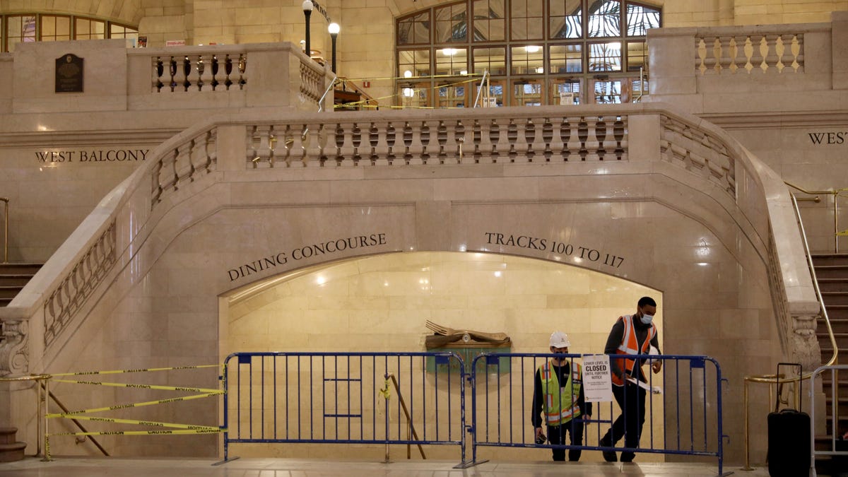 Metro-North Railroad workers emerge from the stairway from the lower level, in an empty Grand Central Terminal, May 1, 2020. 