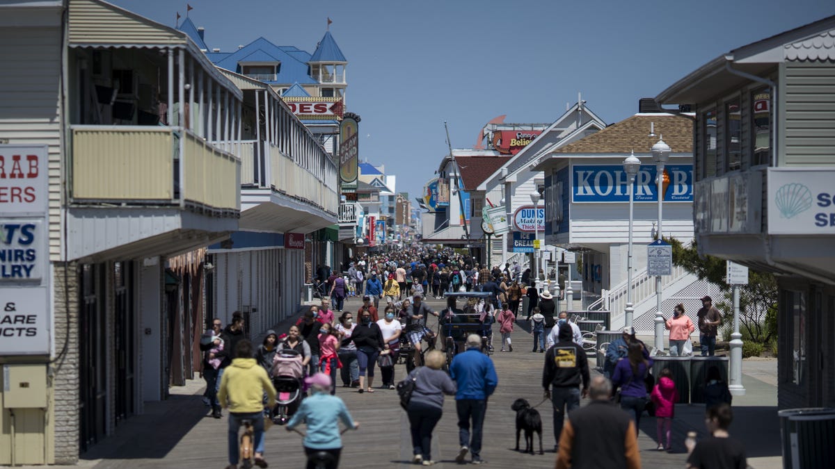 People walk on the boardwalk as the area reopens from the coronavirus pandemic on May 10, 2020 in Ocean City, Maryland. A popular summer tourist destination Ocean City reopened the beach but town officials said the initial reopening was designed primarily for locals.