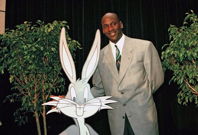 Chicago Bulls Michael Jordan poses with a cutout of Bugs Bunny at a news conference, Tuesday, June 20, 1995, New York.