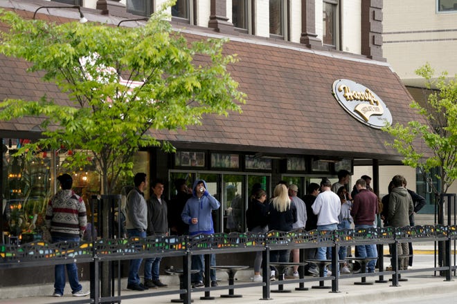 Customers line up outside Harry's Chocolate Shop on State Street, Monday, May 11, 2020 in West Lafayette.