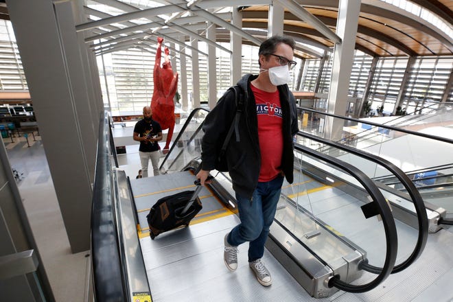 Southwest Airline passenger Robert Civettini wears a face mask as he goes to the boarding gate at Sacramento International Airport in Sacramento, Calif., Monday, May 11, 2020. Beginning Monday Southwest and several other airlines are requiring passengers to wear face coverings or masks during flights. (AP Photo/Rich Pedroncelli)