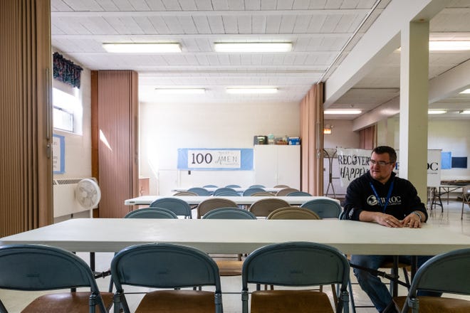 Patrick Patterson,  executive director at Blue Water Recovery and Outreach Center, sits in an empty meeting room Tuesday, April 21, 2020, at Faith Lutheran Church in Port Huron. The nonprofit's office is located at 617 10th St.