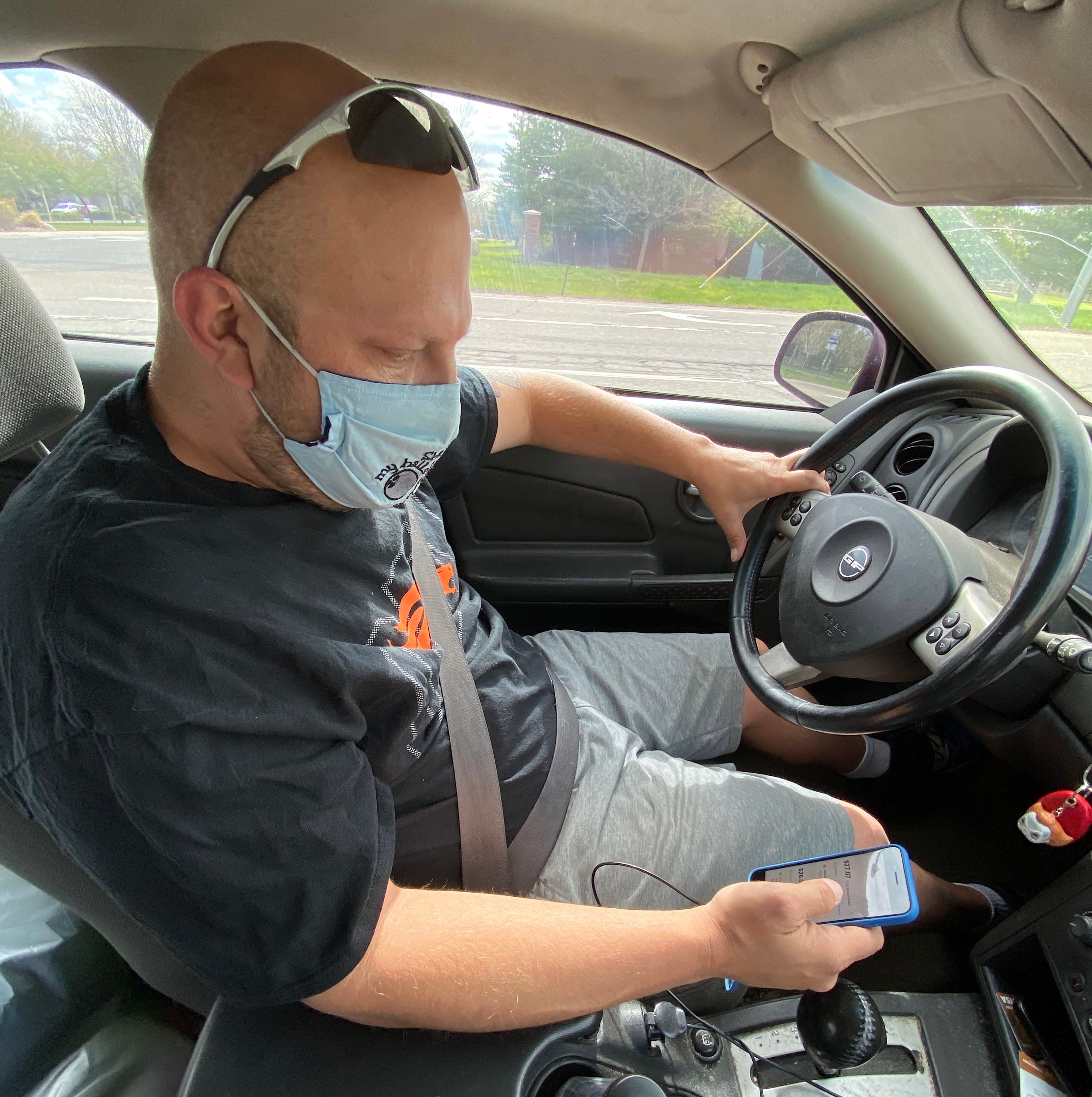 Instacart shopper Jeff Mitchell checks the shopping app for his next assignment after delivering groceries for a customer in Boulder County, Colorado. Instacart shopping is his full-time job.