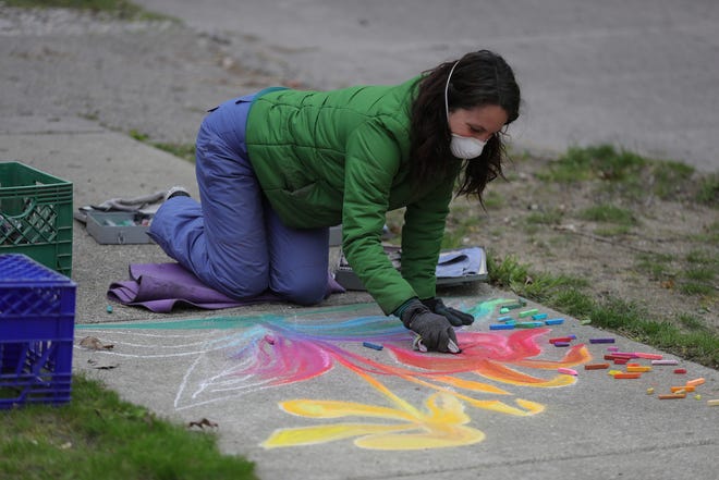 Tiffany Pugmire creates chalk art outside of her home in Oak Park Friday, May 8, 2020.