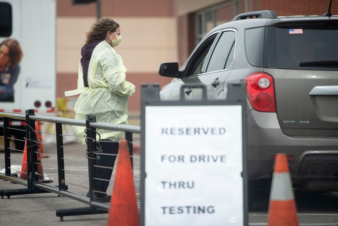 A Rehoboth McKinley Christian Health Care Services employee performs COVID-19 testing at the drive thru testing site in front of Rehoboth McKinley Christian Health Care Services Hospital Wednesday in Gallup. 