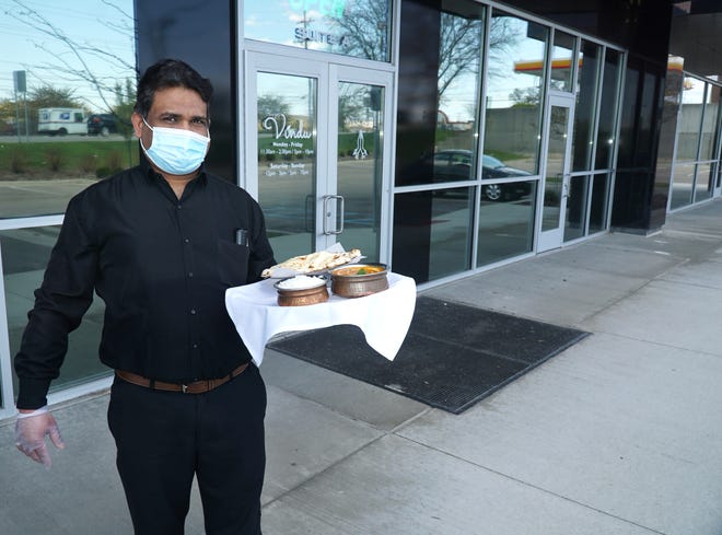 Vindu restaurant employee Rajeev Malgi holds a lunchtime meal of butter chicken, rice and naan bread. The Farmington eatery received approval from the planning commission to establish some outdoor seating at its Grand River Avenue location.