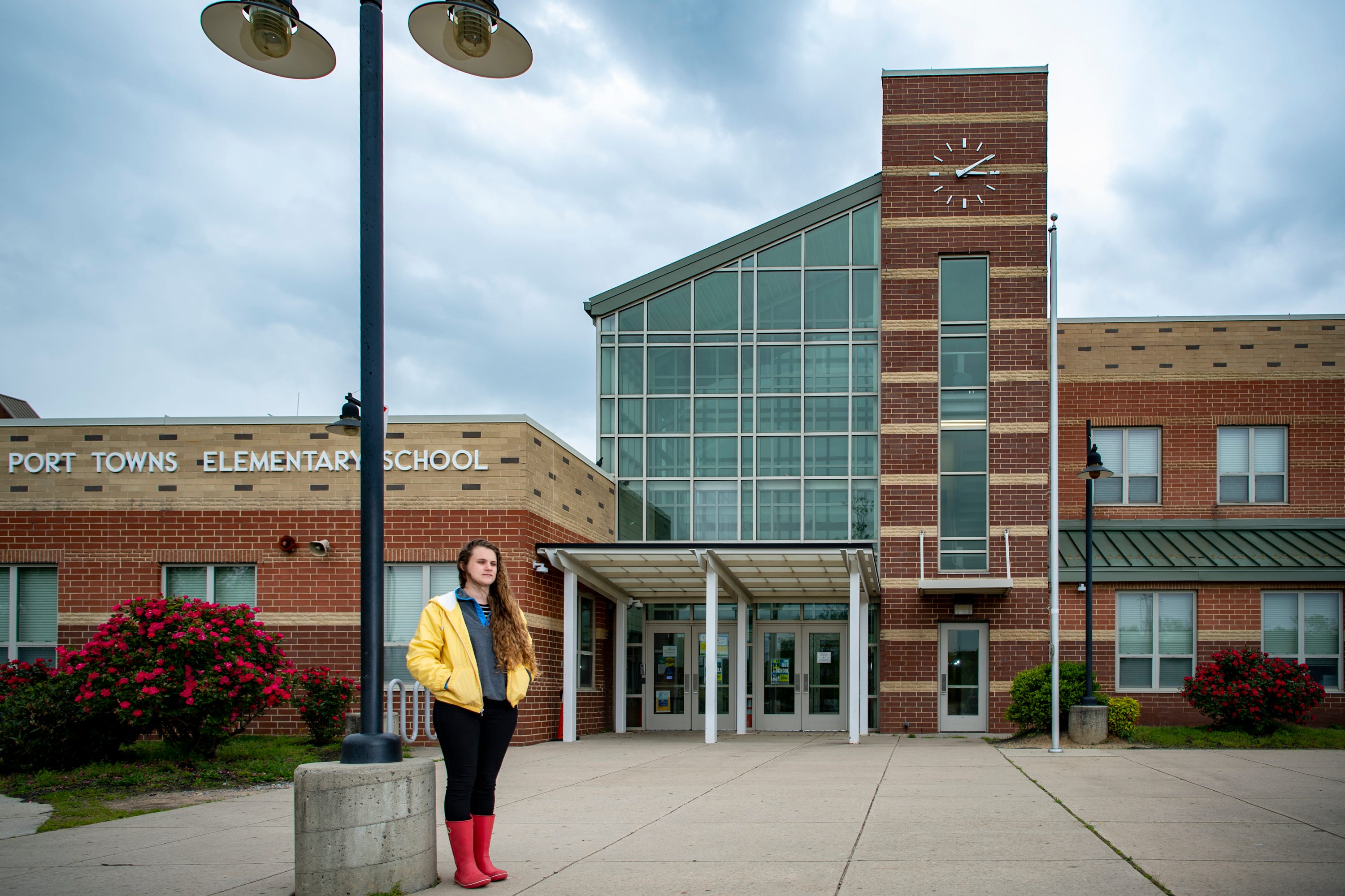 Ariana Tabaku poses for a portrait at the front doors of Port Towns Elementary School.