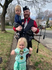 Mike Glackin holds his son Gavin and stands behind his daughter Lily in front of the family's Cranford home on St. Patrick's Day.