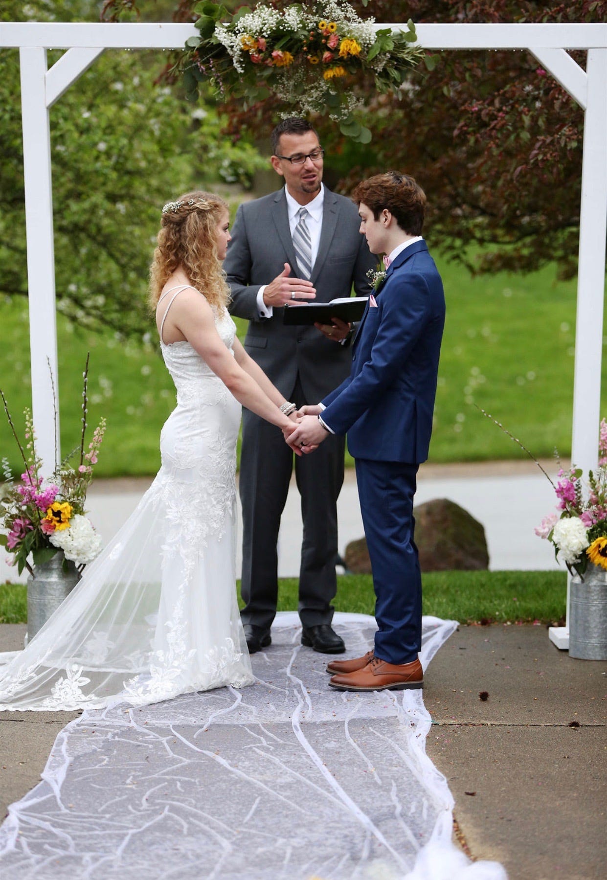 Chase and Sadie Smith stand at their wedding altar set up on the driveway where they shared their first kiss.