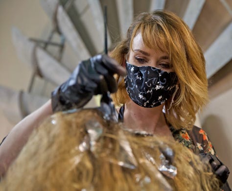 Laura Neill styles a client's hair at the Burlap and Paisley Boutique and Salon on Friday, May 8, 2020 after salons were allowed to reopen for business in Texas.