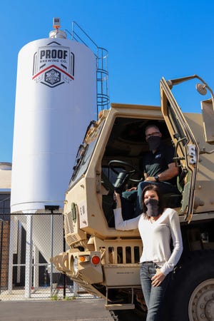 Proof owners Byron and Angela Burroughs with the National Guard truck after distributing hand sanitzer.  "We are eternally grateful to the local community getting beer from us to go and to our retail and hospitality partners that continue to support us and buy our products. It means everything to all of us right now," said Byron Burroughs.