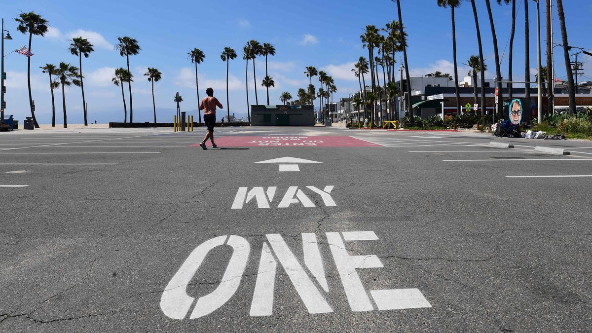 A man walks across a closed parking lot at Santa Monica Beach in Santa Monica, California. Los Angeles County will reopen beaches on Wednesday to limited active use, requiring social distancing.
