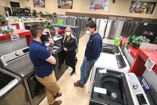 From left, salesman Josh Miller at Witbeck Home Appliance Mart in West Bloomfield speaks with customers Caryn Bittker and her husband Ron as the store has seen a surge in home appliance sales during the COVID-19 stay-home orders.