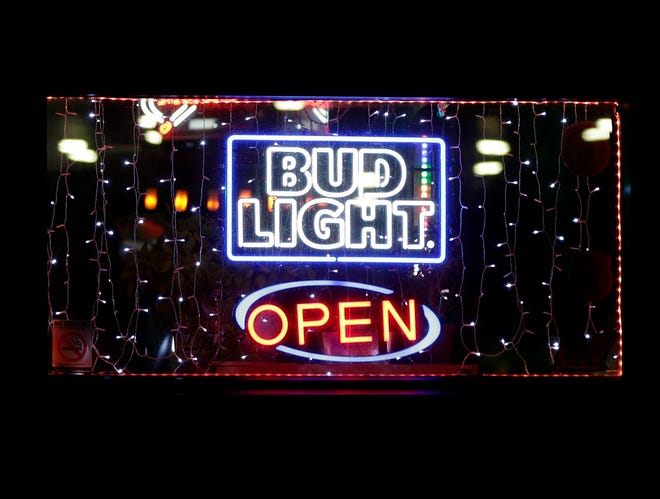 An open sign is lit up in the window of Turn It Up! Tap on May 13, 2020, in Green Bay, Wis., after the Supreme Court overturned Gov. Tony Evers' safer-at-home order. Brown County later issued an order requiring residents and non-essential businesses to comply with safer-at-home rules until May 20.